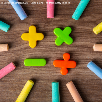 Mathematical symbols and coloured chalks on a table